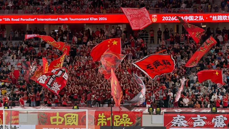 Crowd waving chinese flags at a sporting event.