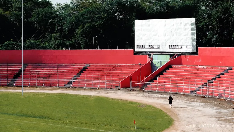 Empty stadium with a scoreboard and red seating.