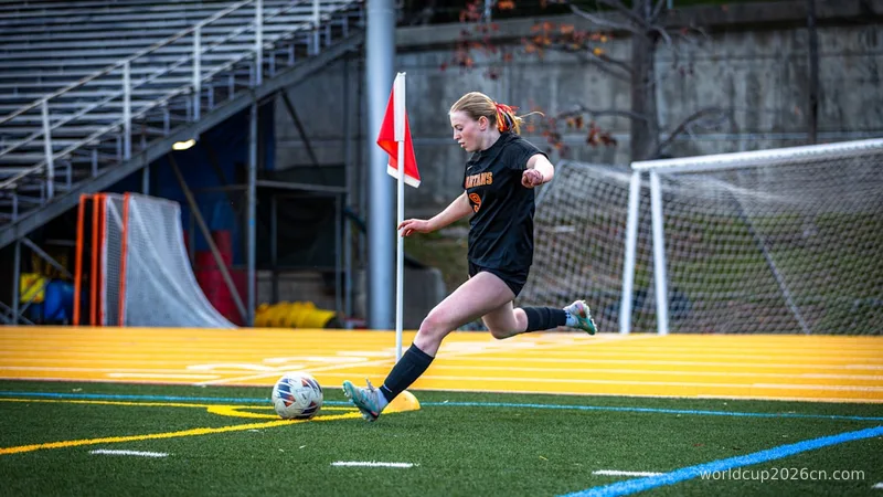 A female soccer player kicks the ball during a game.