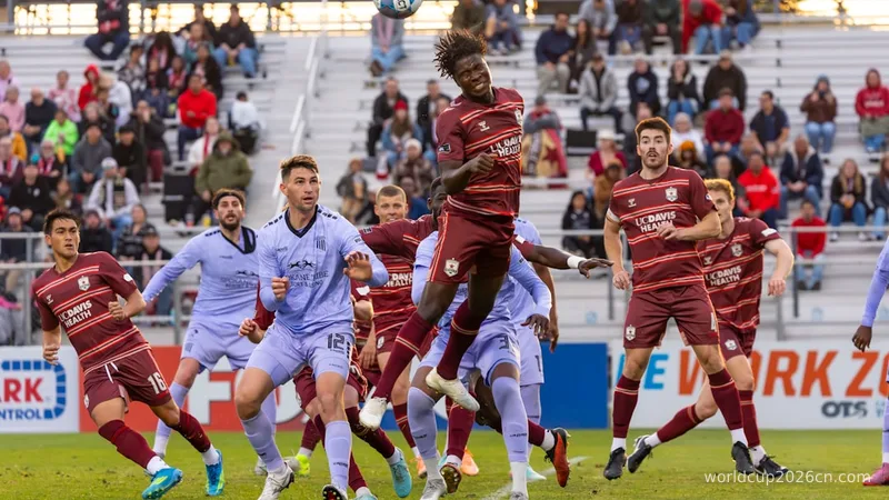 Players leap for a soccer ball during a match.