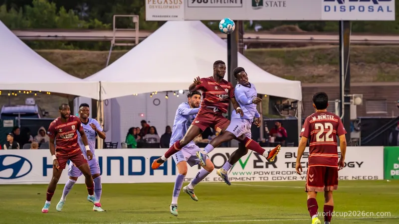 Soccer players jumping for a header during a match.