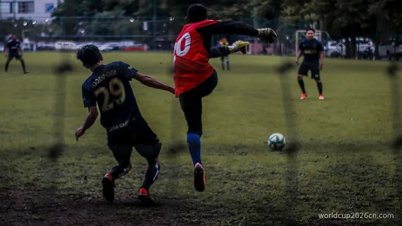 2 men playing soccer on field during daytime