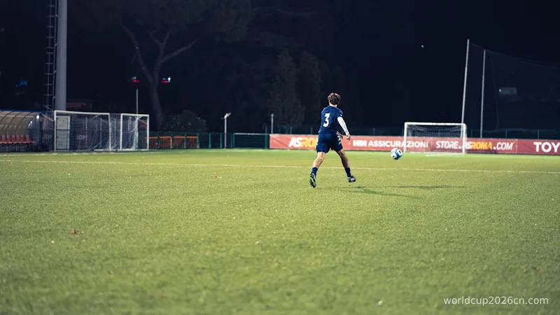A soccer player kicks ball on illuminated field at night
