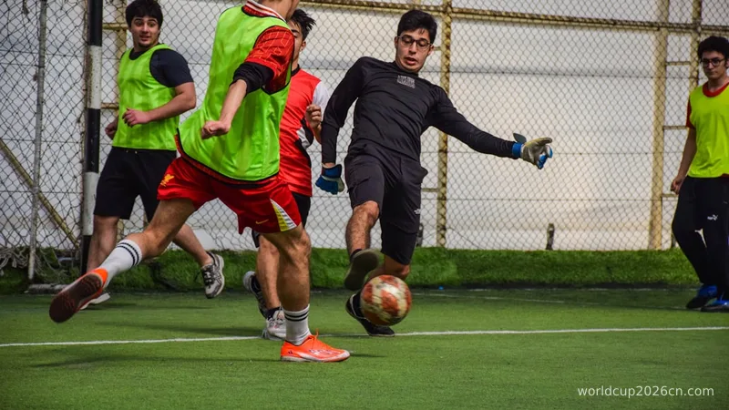 Young men playing soccer indoors on a green field.