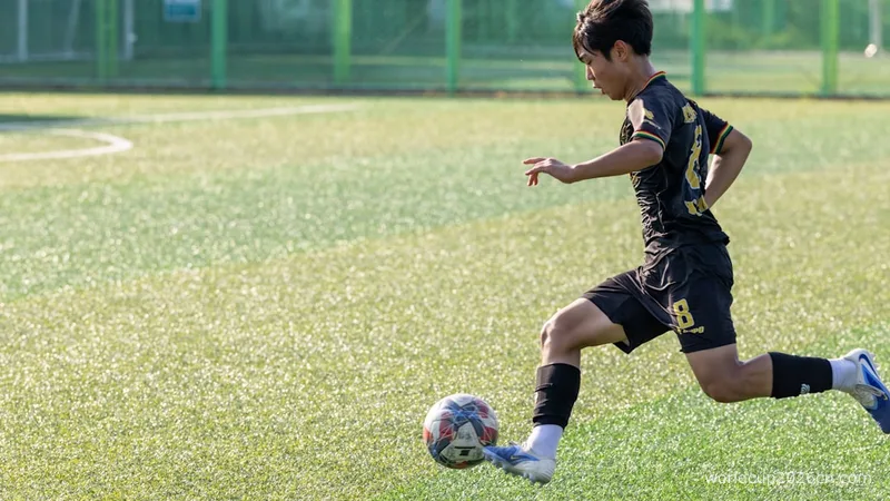 Young man kicking soccer ball on field