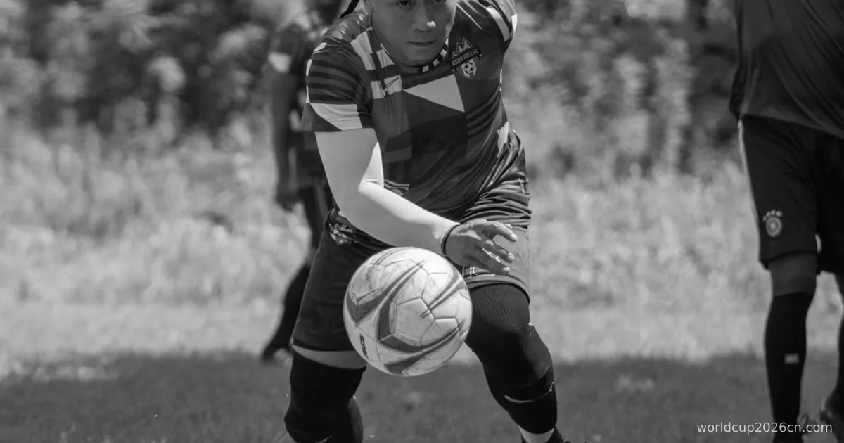 a young man kicking a soccer ball on top of a field