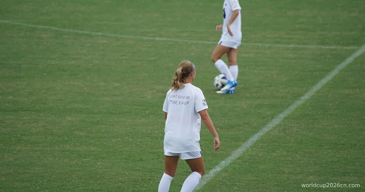 two woman football players on green football field