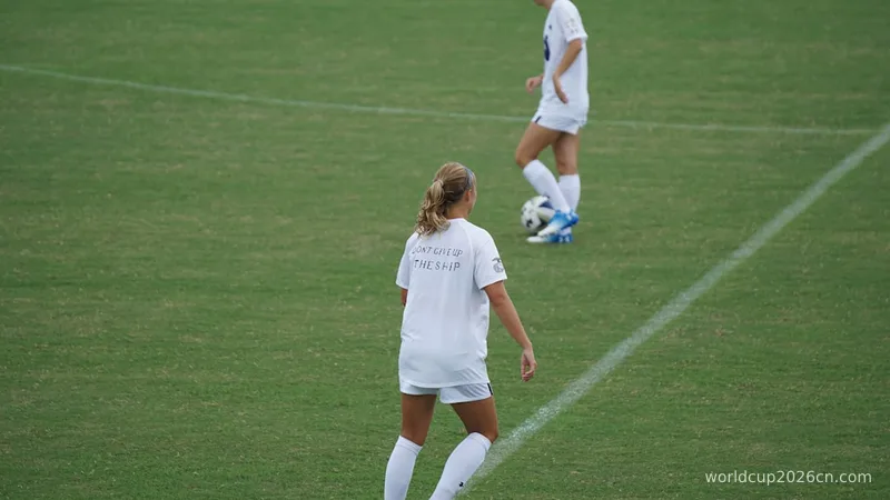two woman football players on green football field